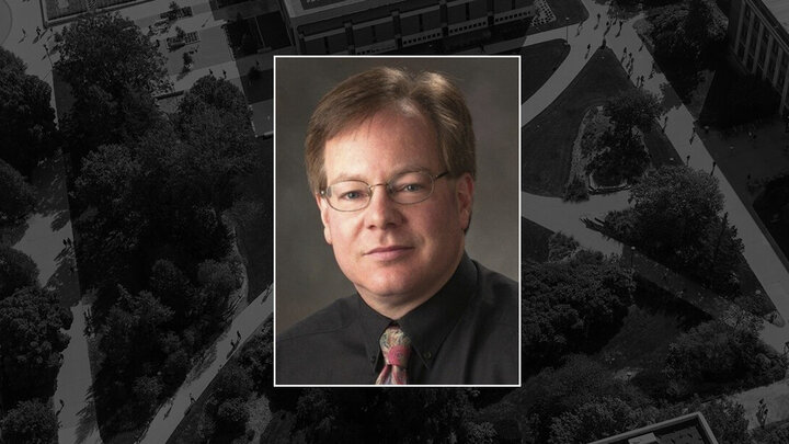 A portrait of Dr. Kevin Lee layered on top of a dark grey-scale aerial view of Cather Garden with the Adele Hall Learning Commons, Louise Pound Hall, and Hamilton Hall visible along the edges.
